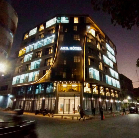 Façade moderne de l'Axel Hôtel à Dakar, éclairée de nuit, conçue par un architecte à Dakar.